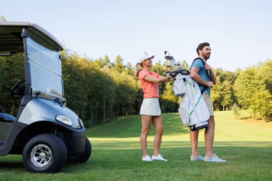 Zwei Golfer mit E-Cart auf dem Fairway